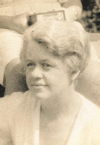 Vintage portrait of a woman with a soft up-done hairstyle and a white blouse.