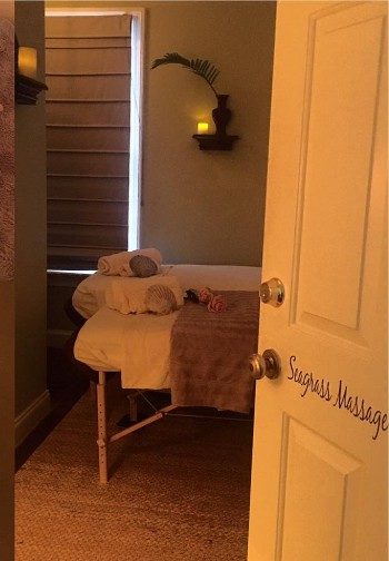 View of massage table set up with towels from a door labeled 